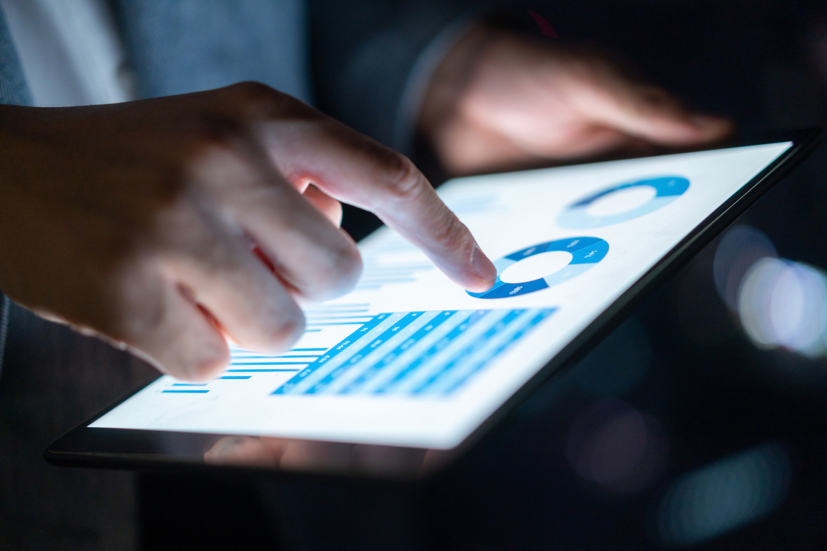 A person holding an ipad with generic graphs 