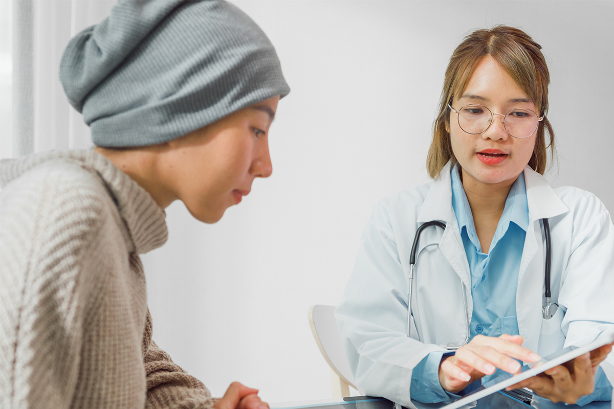 Provider and oncology patient talking in an office. Doctor is holding tablet