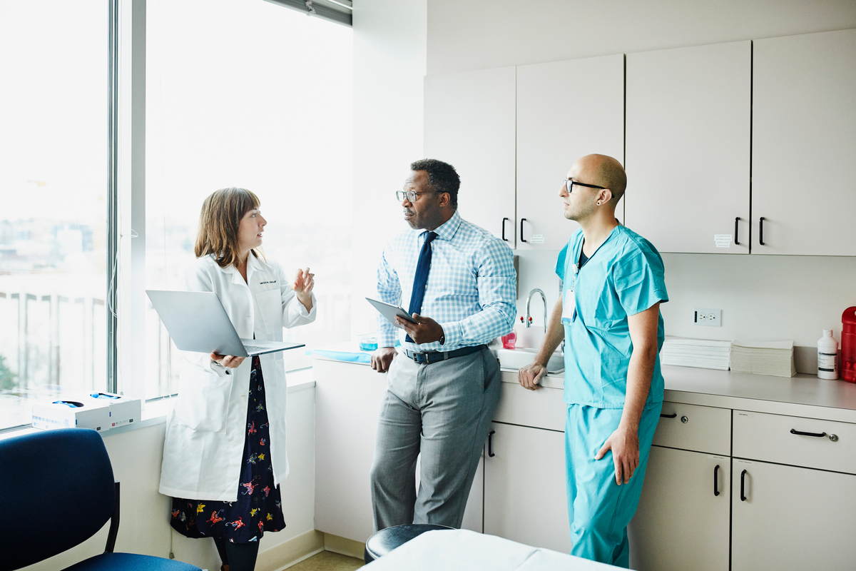 Three providers standing in a break room talking