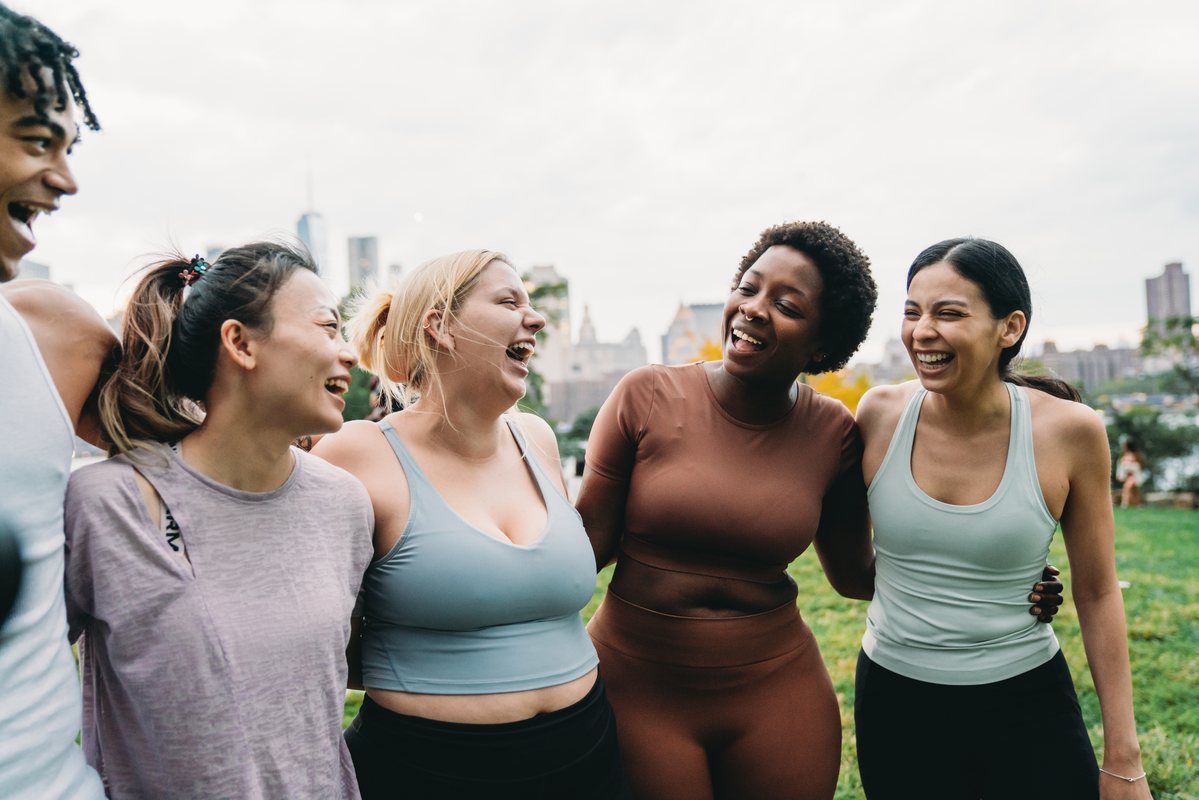 Group of five diverse friends sitting on a patio laughing