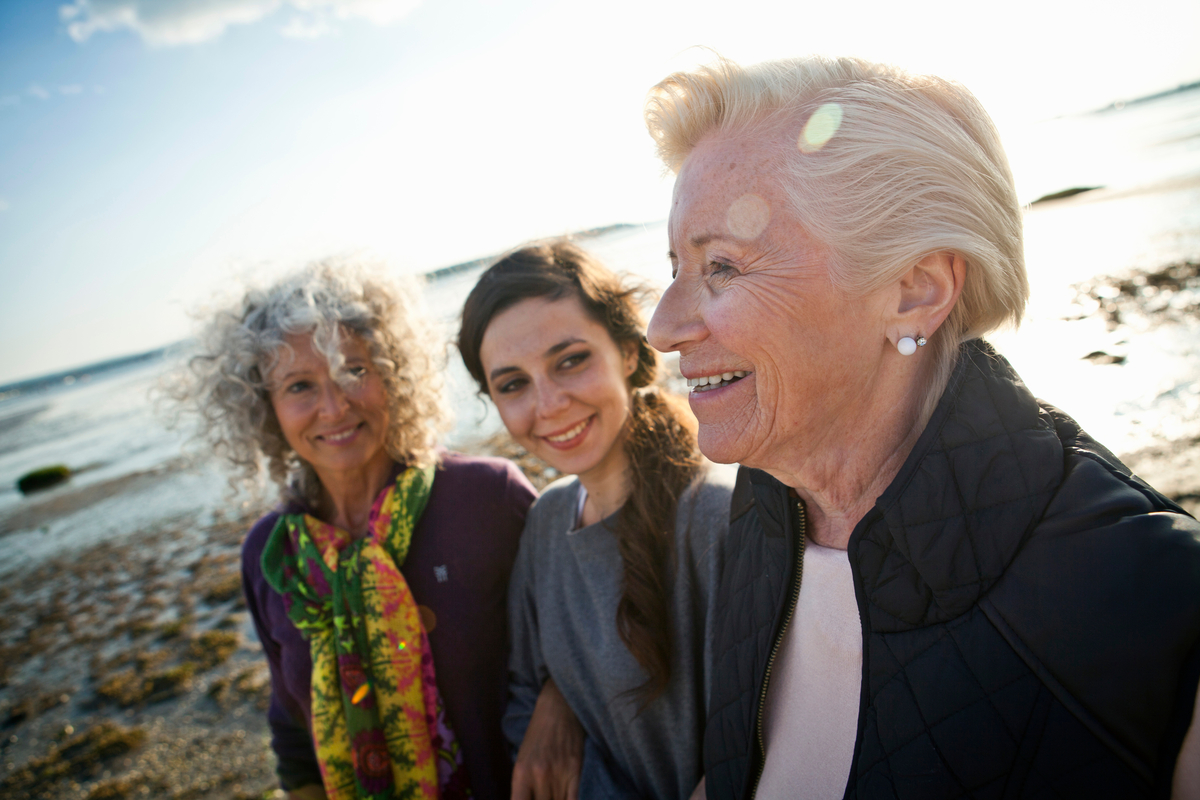 512138141 A diverse group of three women standing on a beach.