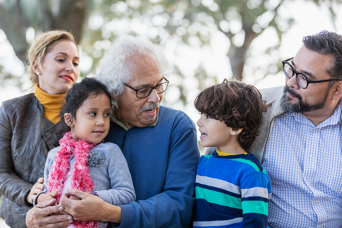 Family of four visiting grandpa at a park