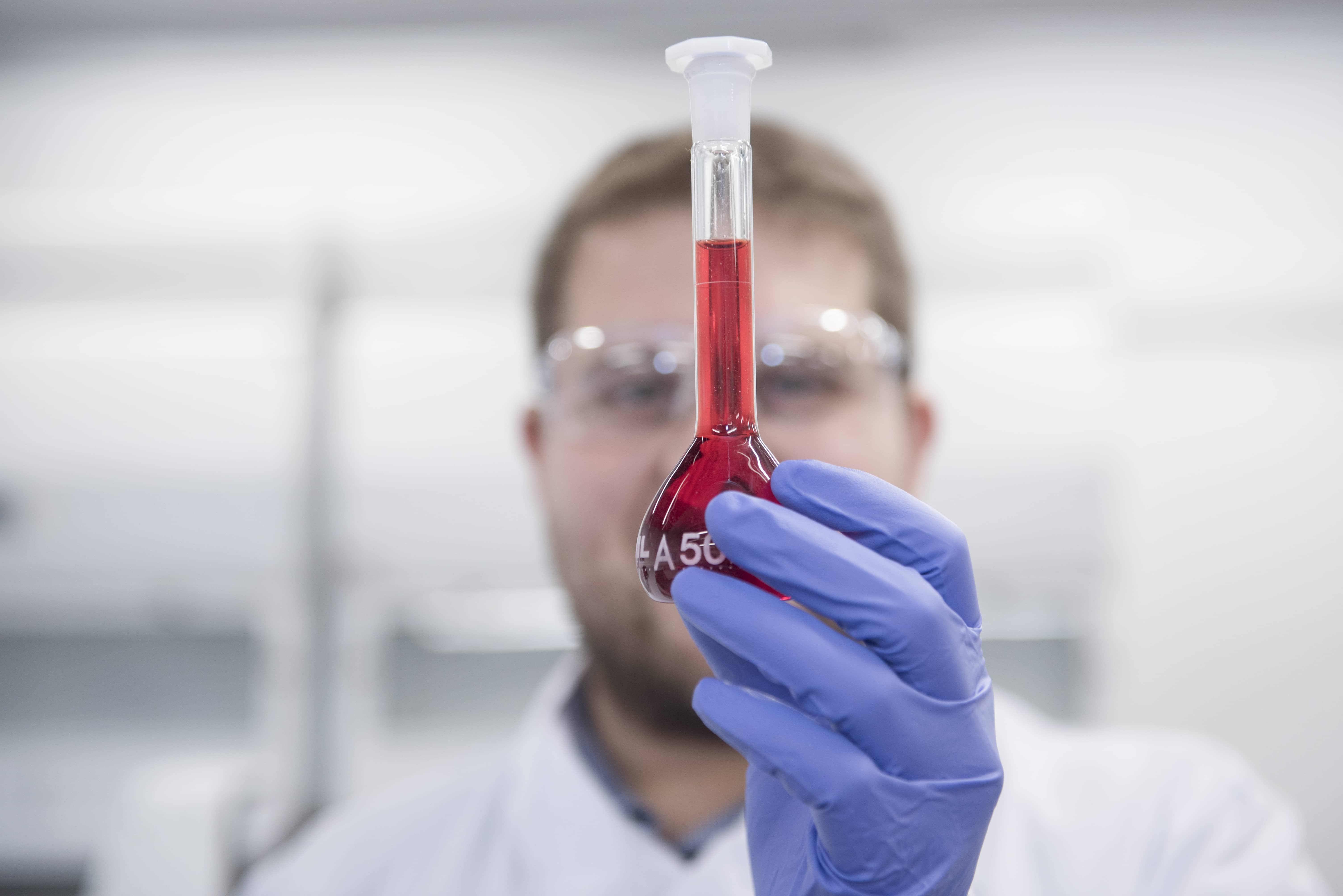 Scientist holding a beaker with red liquid Future vision