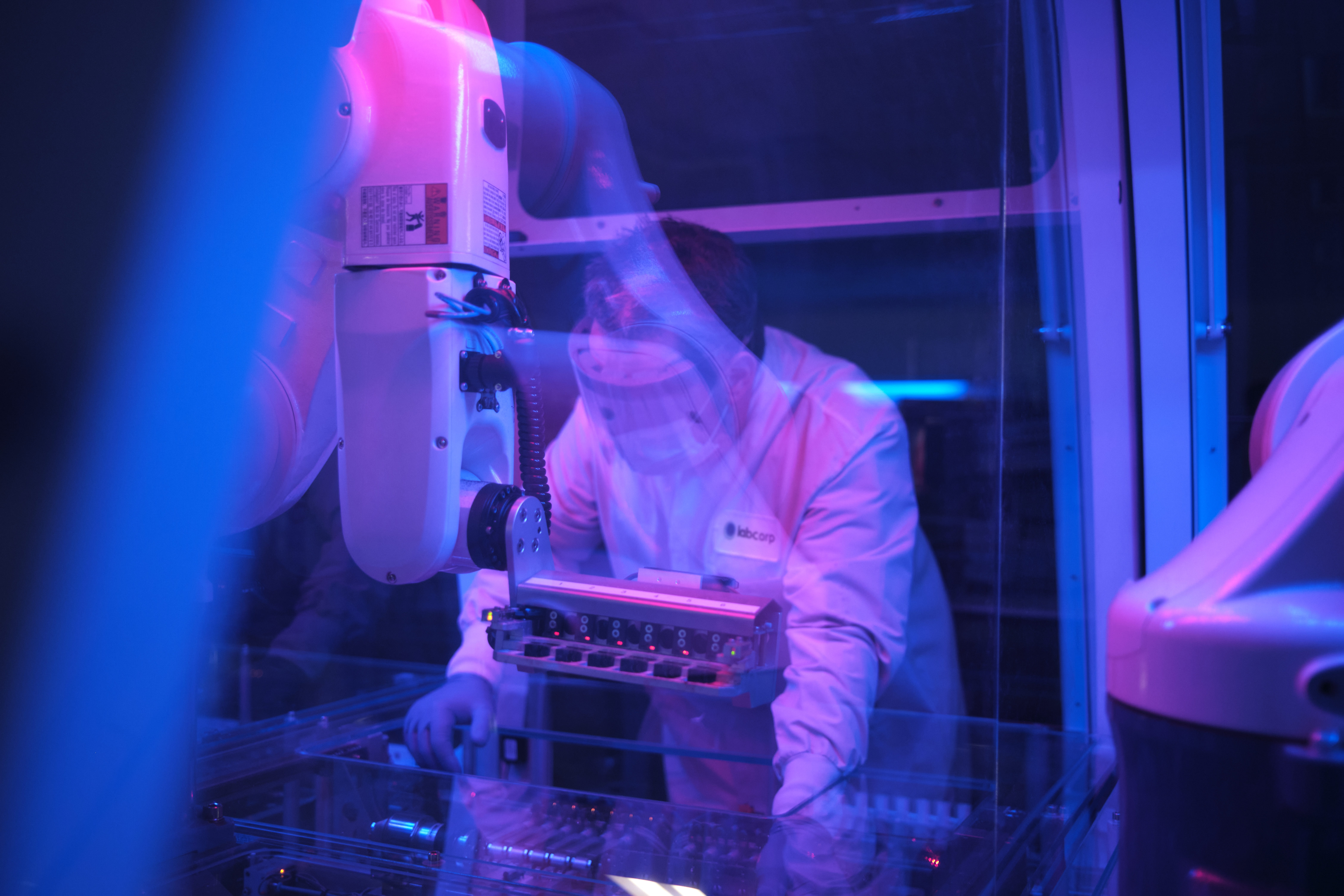 Científico de Labcorp en un laboratorio con iluminación azul y púrpura