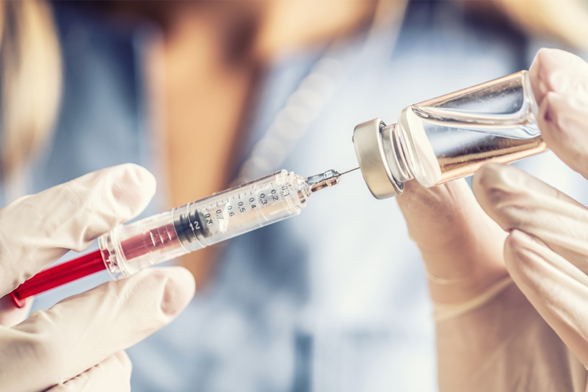 Provider extracting a vaccine from a vail into a needle